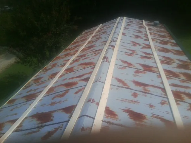 Rusted metal roof panels with new wood purlins before replacement — Storm Damage Roof Repair in Locust Fork by Roofing Brothers