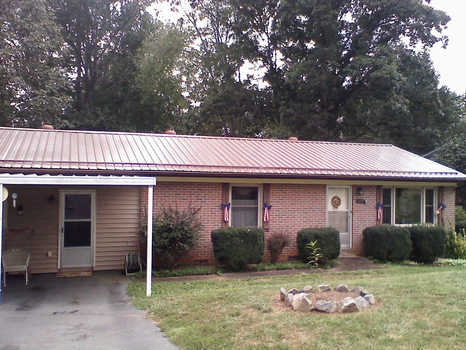 Bronze metal roof and carport on a brick ranch home — Roof Repair work by our crew in Locust Fork